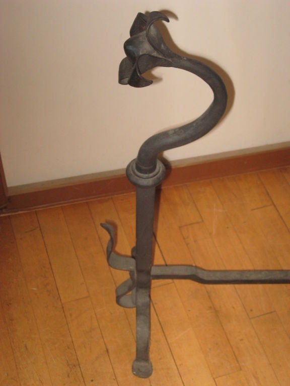 Hand-forged iron andirons with stylized sunflowers tops.