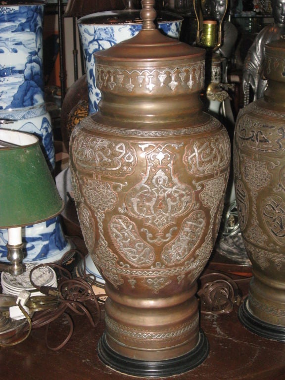 Paire de lampes du Moyen-Orient en métal mélangé, laiton, sterling et cuivre, chacune ayant une écriture différente sur des bases en bois, câblées.