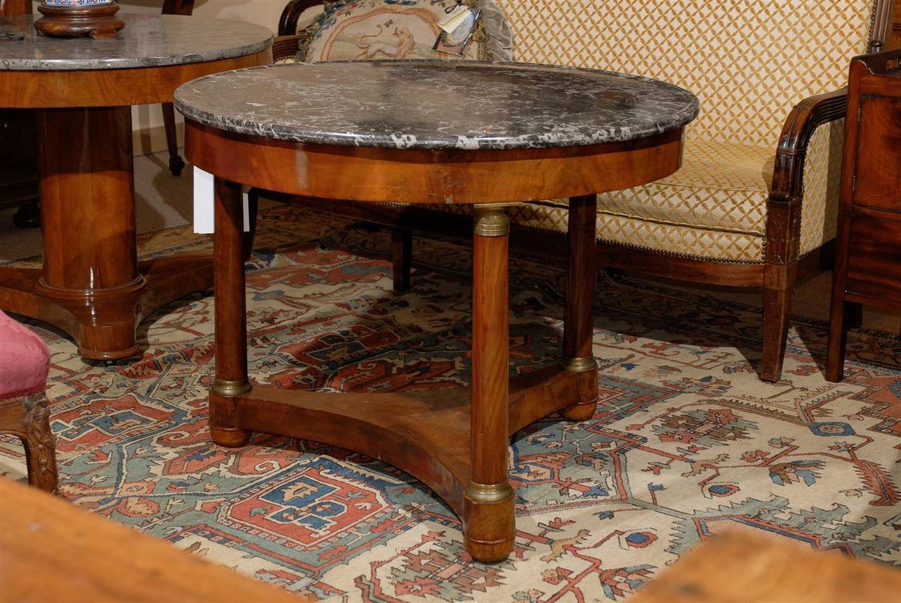 A 19th century French empire mahogany Gueridon or center table with ormolu and grey marble top, circa 1820.