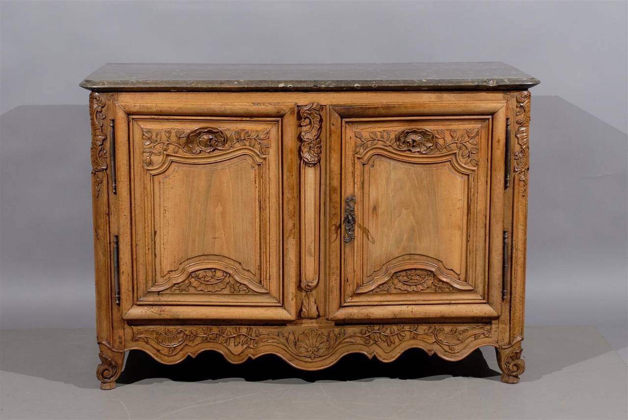 An exceptional French walnut Regence buffet with a thick grey oyster marble top, deep scallop shell and foliage carving on doors and apron ending in cabriole feet. The doors with original locking mechanism. 

William Word Fine Antiques: Atlanta's