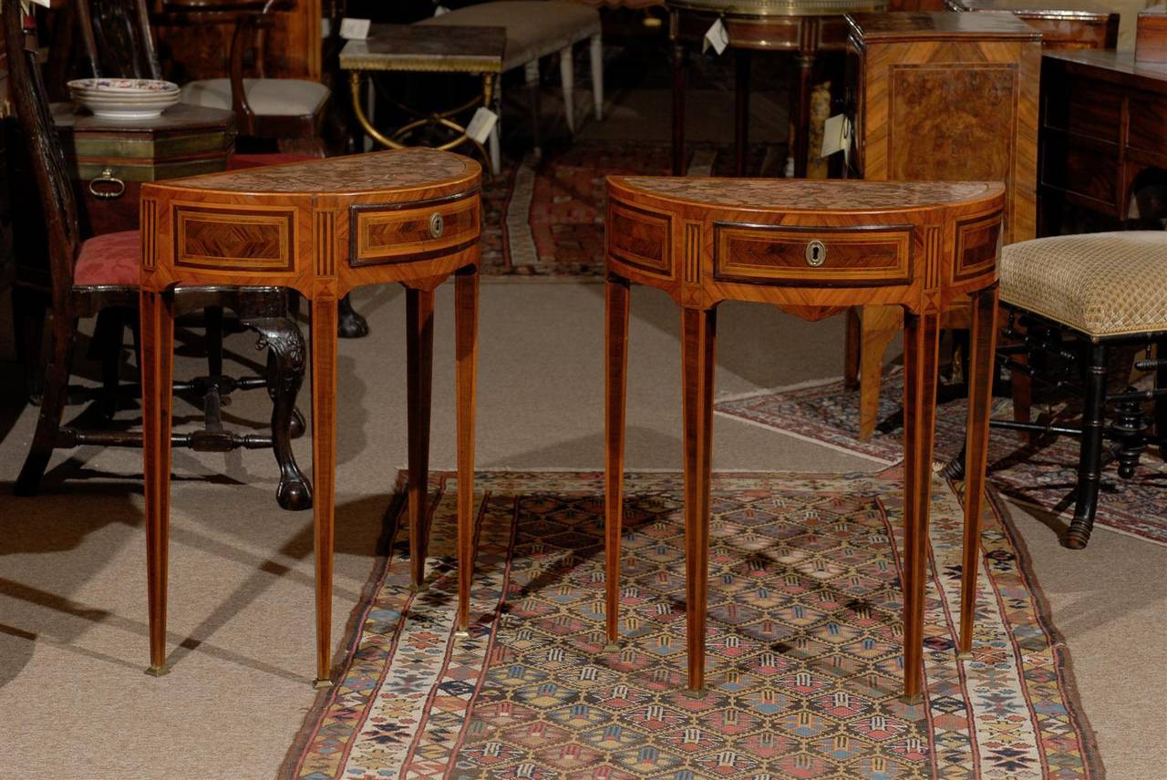 A pair of petite Italian Neoclassical style demilune consoles with inset marble tops, drawers and inlay. 

William Word Fine Antiques: Atlanta's source for antique interiors since 1956.