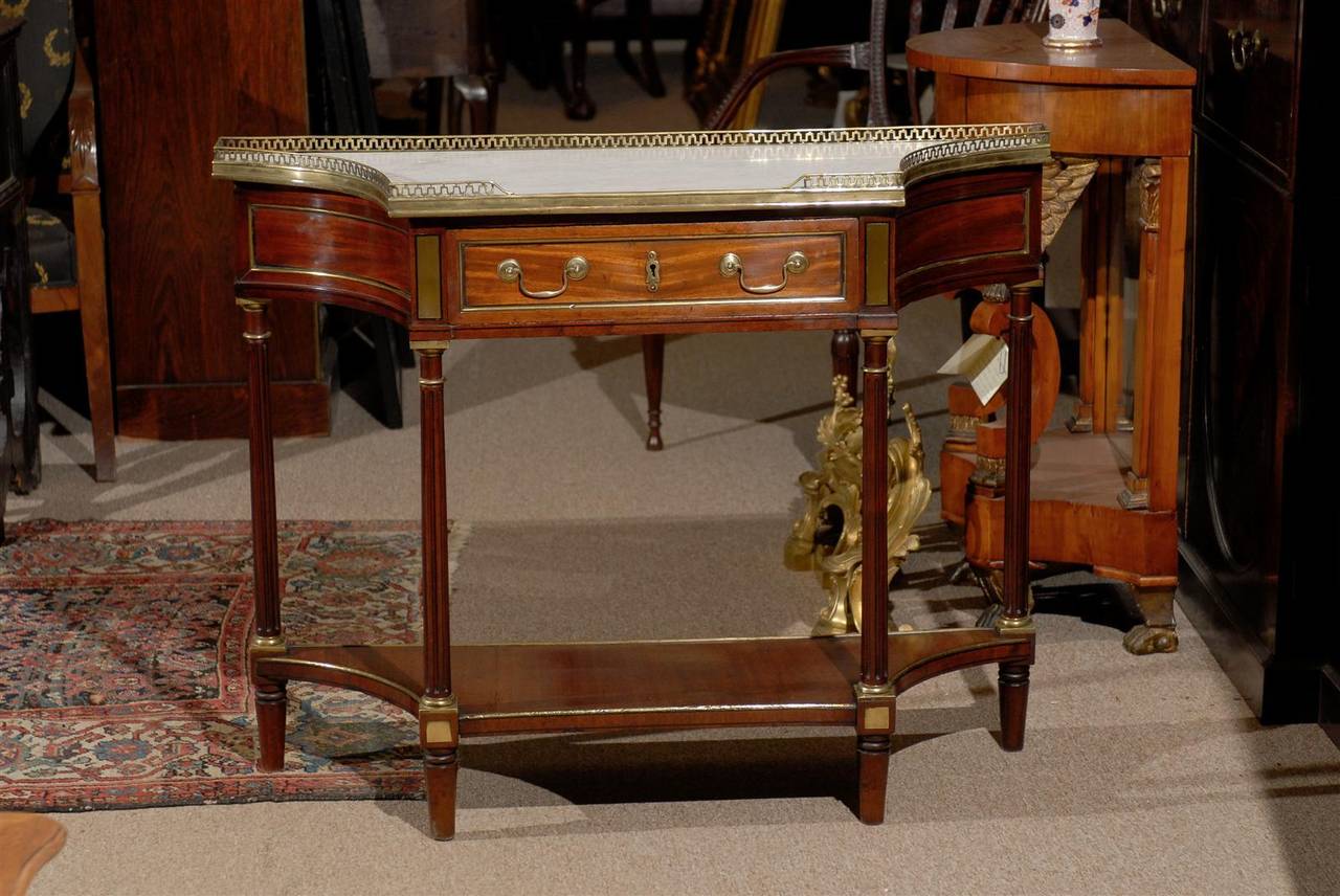 A Louis XVI French walnut dessert table with white marble top, brass gallery and inlay, drawer and lower shelf. 

William Word Fine Antiques: Atlanta's source for antique interiors since 1956.