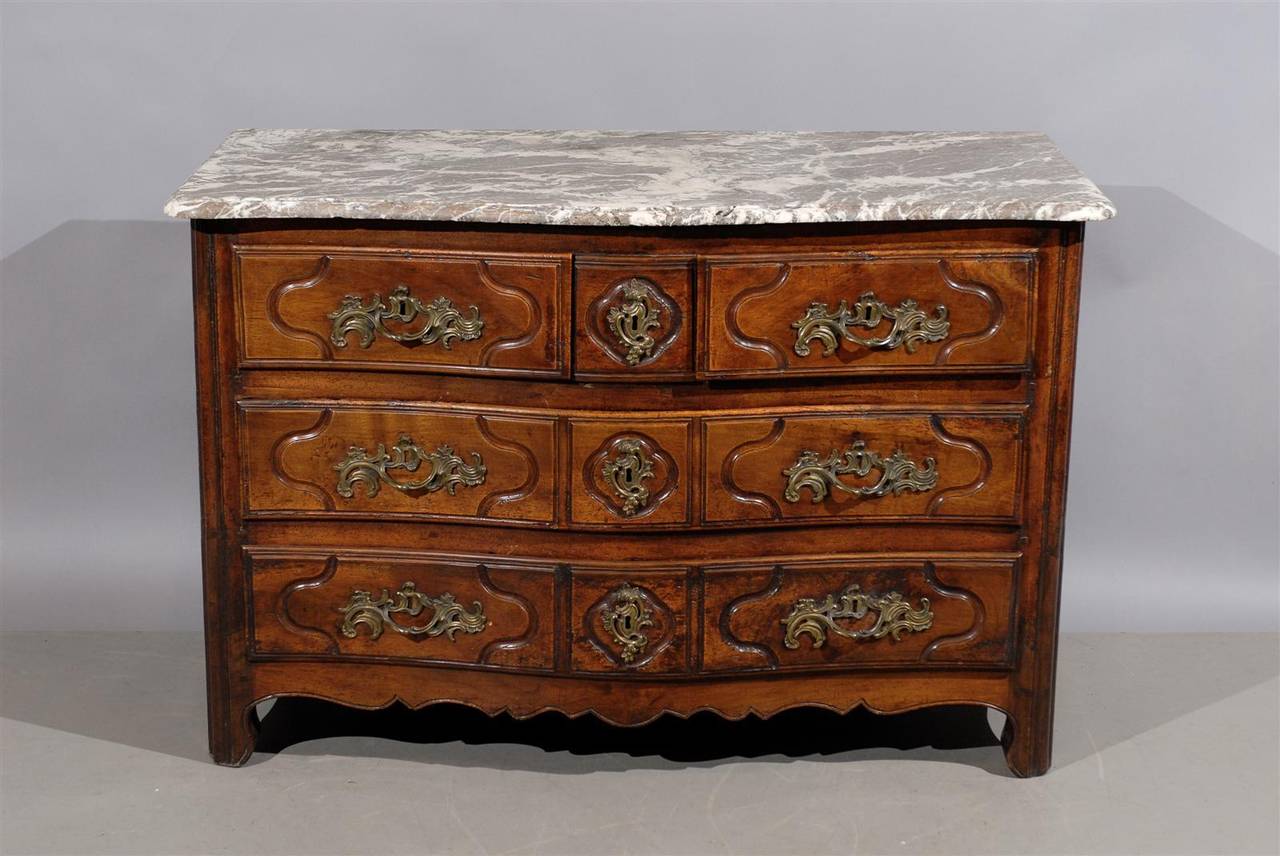 A French Provincial Louis XV walnut commode with marble top, serpentine front, 3 drawers with bronze hardware and shaped apron. 

William Word Fine Antiques: Atlanta's source for antique interiors since 1956.