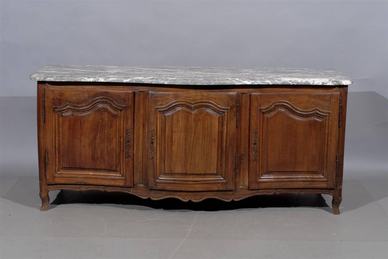 A Louis XV walnut enfilade with grey marble top, paneled doors with interior shelving, shaped apron and cabriole feet. 
