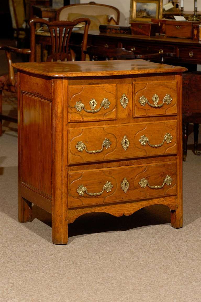 A petite 18th century provincial walnut commode with 4 drawers, gilt-bronze hardware and shaped apron below. 

William Word Fine Antiques: Atlanta's source for antique interiors since 1956.