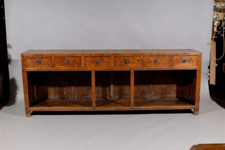 A long narrow Chinese pine console table/server with 4 drawers with brass pulls. 

William Word Fine Antiques: Atlanta's source for antique interiors since 1956.