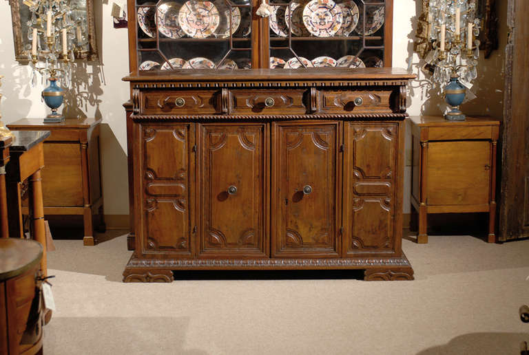 A large walnut credenza with carved paneled 3 drawers and 2 doors, Italian in origin and dating from the 18th Century.