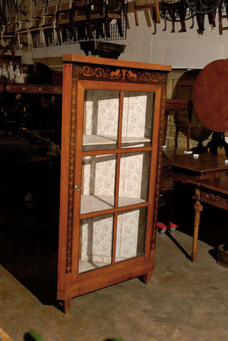 Biedermeier period corner cabinet in fruitwood with glazed glass doors, Germany 19th century. Inlaid with lions and scroll foliate design.

William Word Fine Antiques: Atlanta's source for antique interiors since 1956.