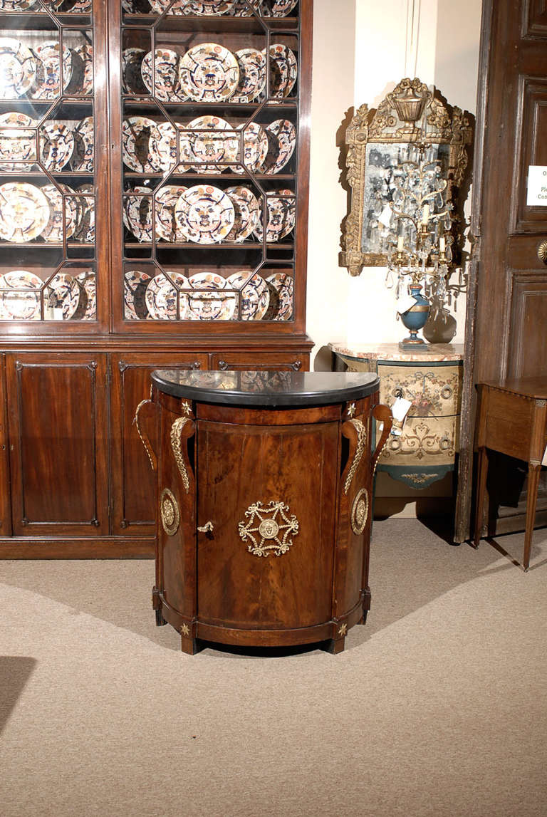 A Russian  figured mahogany demilune with ormoplu mounts & black marble top.  

William World Fine Antiques: Atlanta's source for antique interiors since 1956.