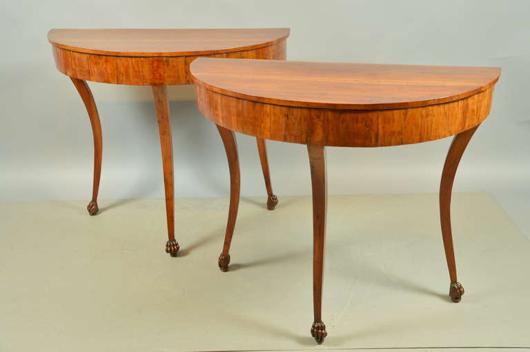A pair of Neoclassical Italian demilune consoles in fruitwood with saber legs and paw feet. 

William Word Fine Antiques: Atlanta's source for antique interiors since 1956.