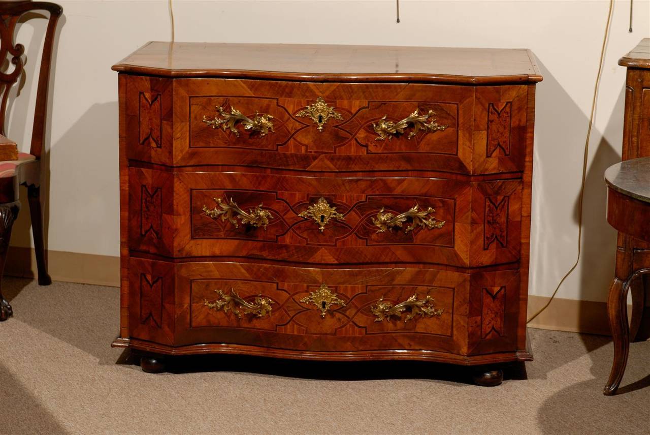 A large 18th century German walnut commode with inlay, shaped front and three drawers mounted with bronze dore pulls.

To view our complete inventory, please visit us online.