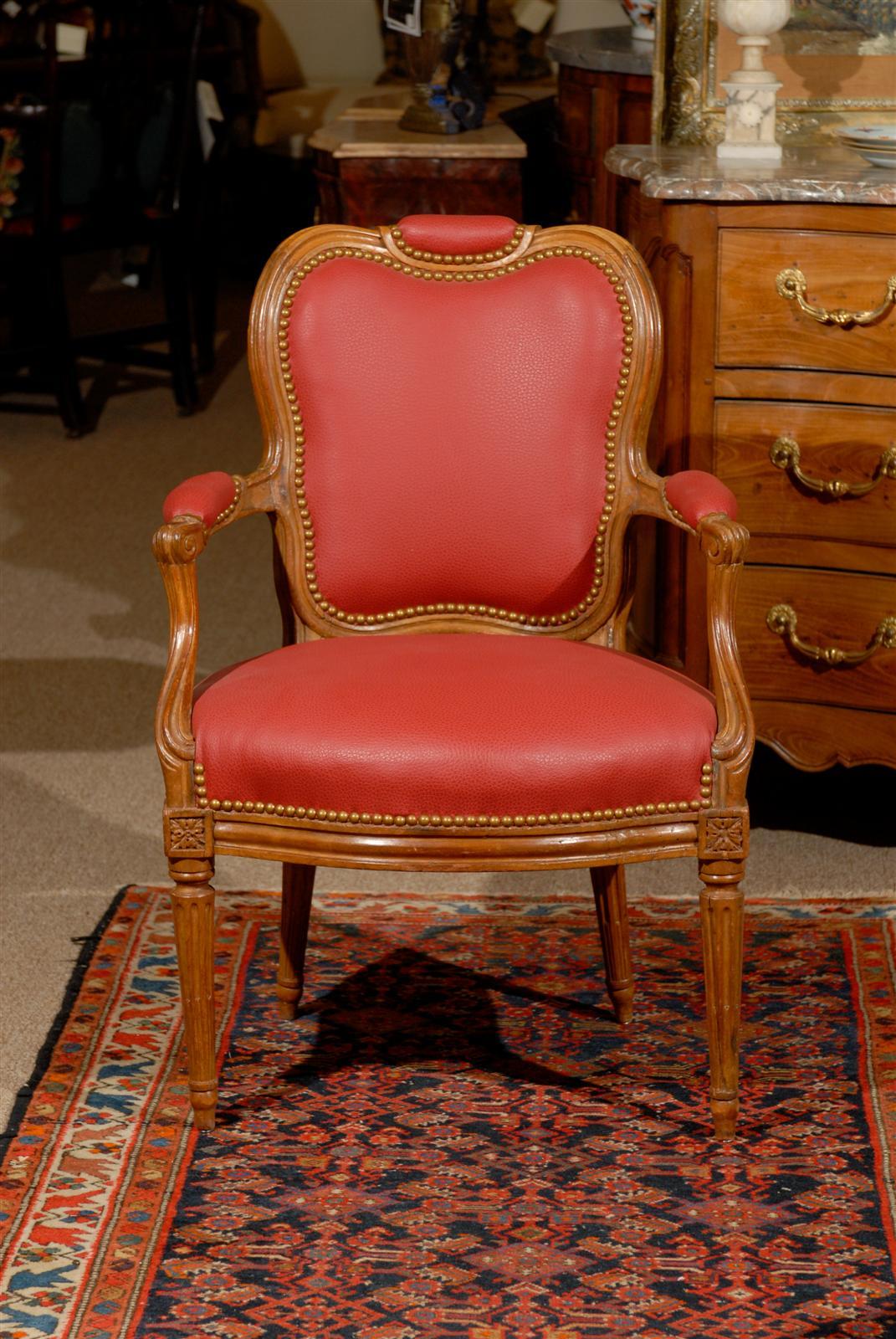 A pair of transitional Louis XV or  Louis XVI fauteuils in beechwood and leather upholstery, French in origin and dating from the late 18th century.