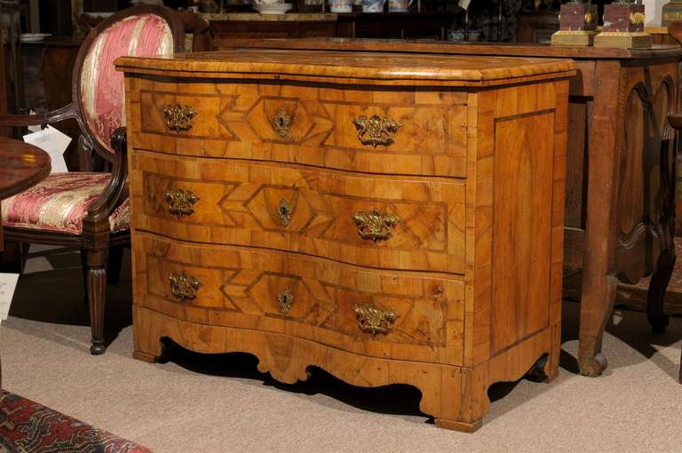 A walnut inlaid commode with serpentine front, 3 sliding drawers with bronze hardware and shaped carved apron and feet 

William Word Fine Antiques: Atlanta's source for antique interiors since 1956.