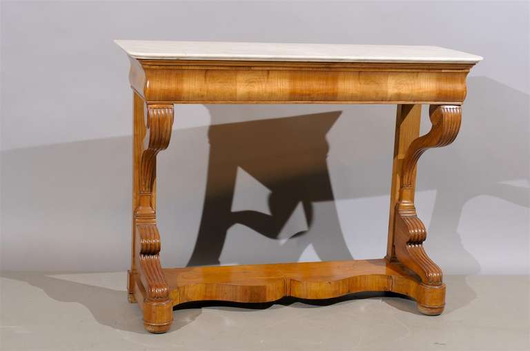 A Biedermier style console table in fruitwood with white marble top and frieze drawer. 

William Word Fine Antiques: Atlanta's source for antique interiors since 1956.