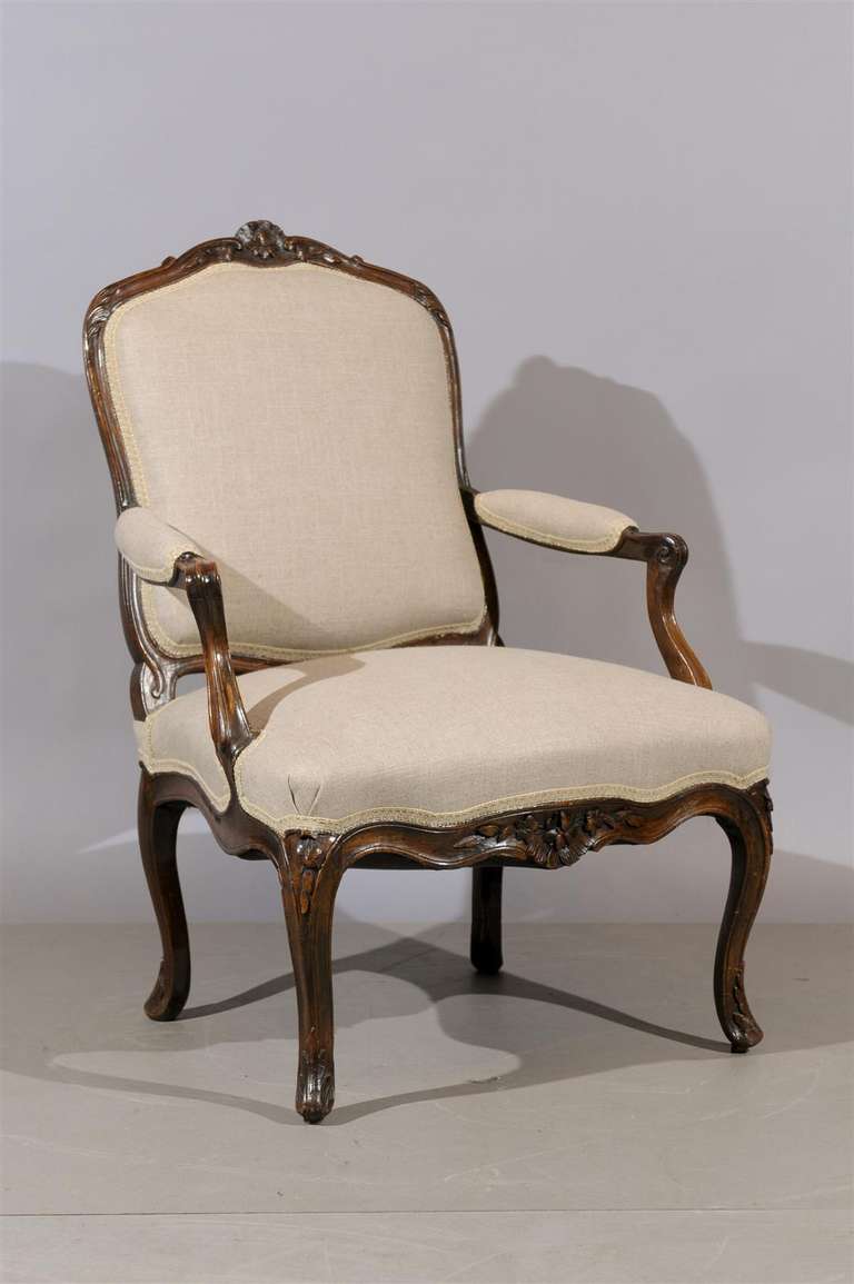 A French Louis XV Style walnut fauteuil with arched carved back with flower carving, curved arms , new linen upholstery and cabriole carved feet.    

William Word Fine Antiques: Atlanta's source for antique interiors since 1956.
