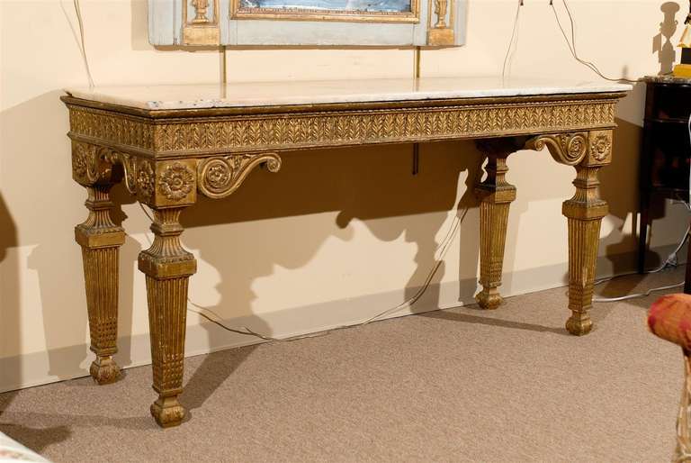 A long Italian Neoclassical stlye gilt-wood console with cream marble top. 

William Word Fine Antiques: Atlanta's source for antique interiors since 1956.