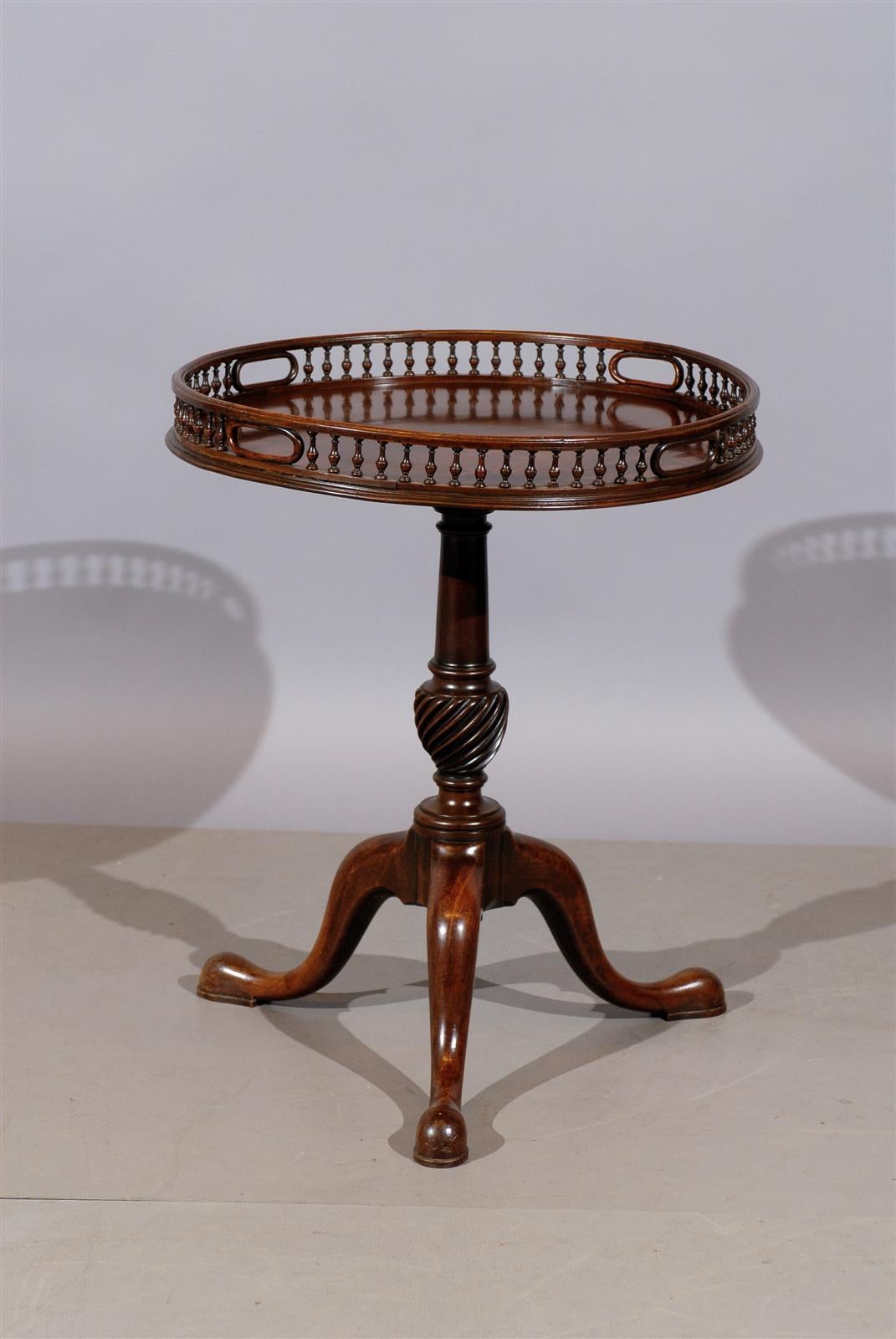 An early 19th century (or earlier) English mahogany table with unusual gallery, Tripod pedestal base and pad feet.