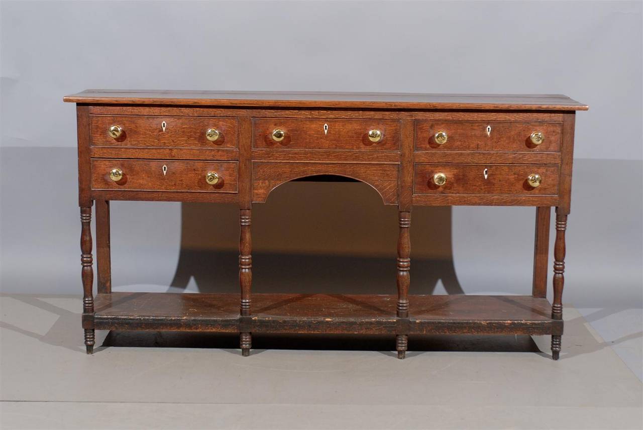 A long and narrow 19th century English oak dresser base or console with five drawers and lower shelf.

To view our entire inventory, please visit our website.

William Word Fine Antiques: Atlanta's source for antique interiors since 1956.