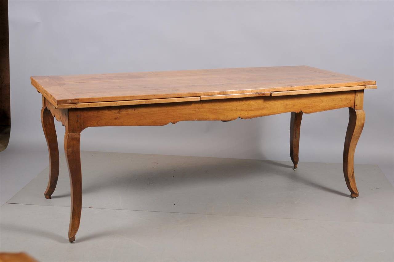 A French Louis XV style fruitwood farm table with pull-out leaves and cabriole legs. 

