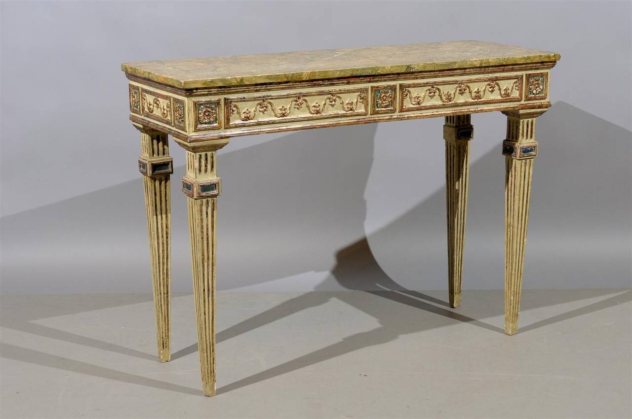 A narrow Italian neoclassical style polychrome painted and parcel-gilt console table with faux marbleized top and fluted legs, circa 1890.