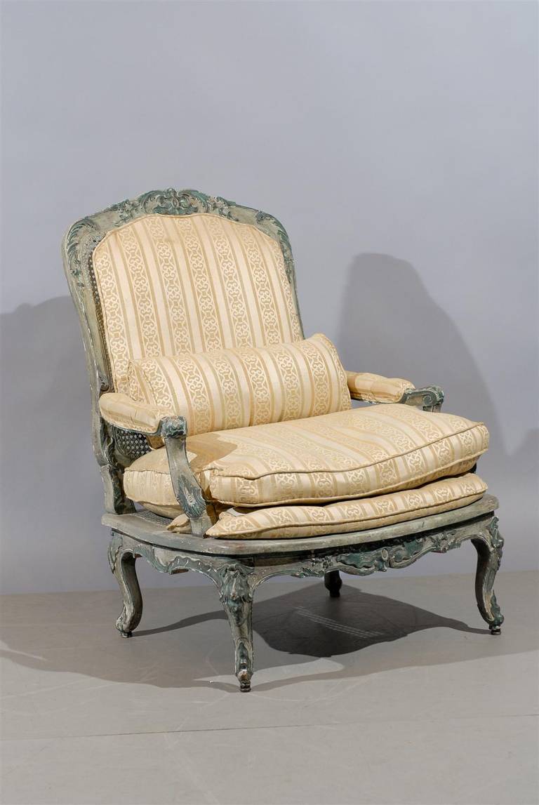 A large Regence style painted Fauteuil with Cane and Upholstery, dating from the Early 19th Century and French in Origin.