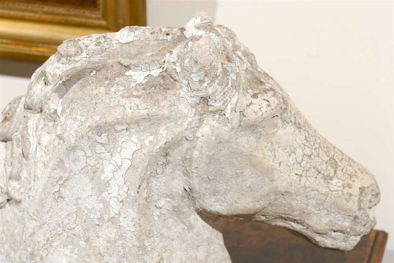 A French horse head from the mid-20th century cut at the withers with beautiful naturalistically carved details such as the eyes, the flowing mane, soft muzzle and flared nostrils as well as the rim of the bone curved along the bottom of the cheek.