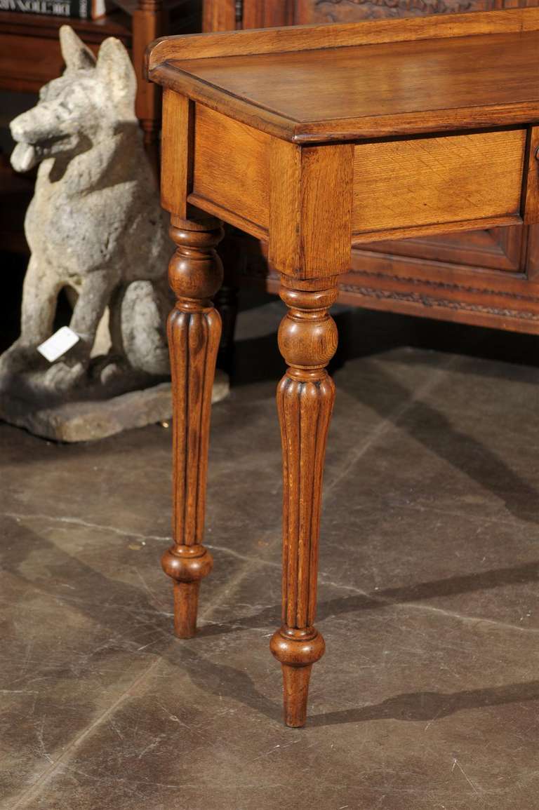 English 1880s Oak Console Table with Single Drawer, Shield Motif and Reeded Legs 3