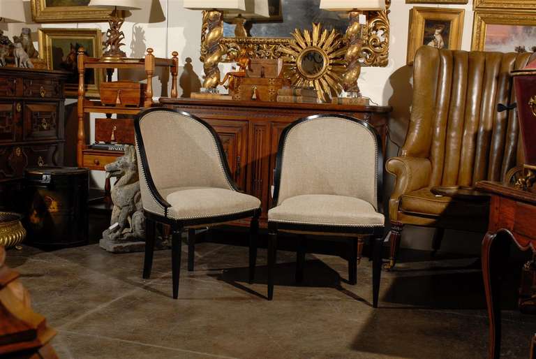 Pair of upholstered Art Deco ebonized chairs. Legs are fluted.