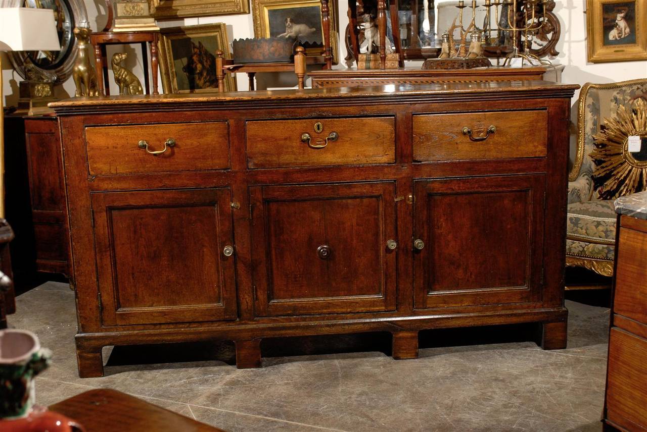 English server or cabinet of elmwood with three drawers and three doors.