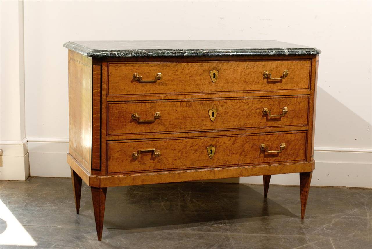 This exquisite French burl wood Louis XVI style three-drawer commode features a beautiful green veined marble top with beveled and rounded edge over three hand-cut dovetailed drawers. The piece is adorned with a variety of delicate banding styles