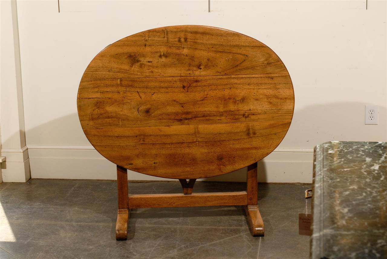 Oval French wine tasting table with lovely wood and patina.