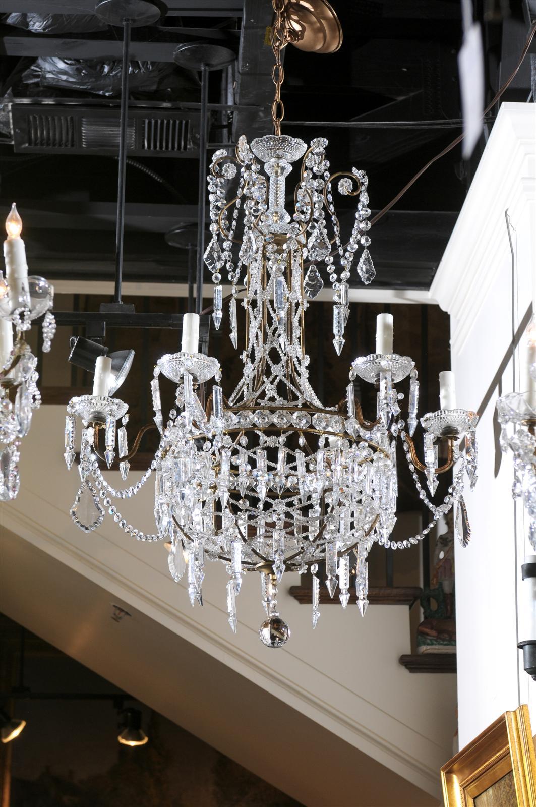 An Italian crystal six-light chandelier from the early 20th century. This exquisite Italian crystal chandelier features a delightful vertical silhouette. A metal armature is the support for the abundant variety of crystals. The elegant vertical