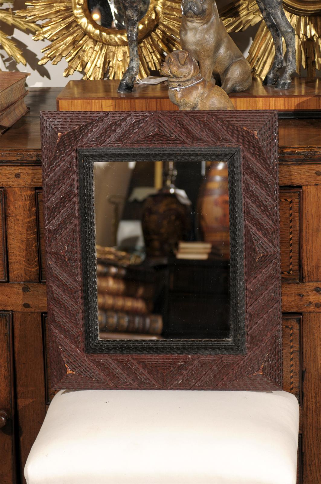 A rectangular French wooden Tramp Art mirror from the early 20th century. This piece consists of different friezes of the same size assembled into a variety of patterns. Relief is a very important part of Tramp Art and in this case the stacked lines