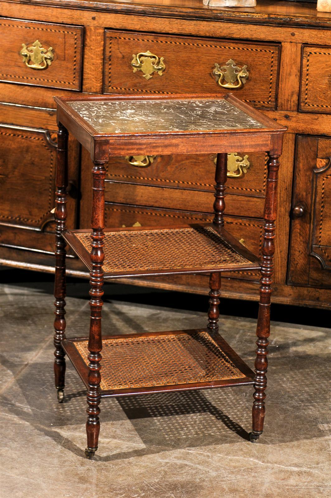 This French etagere or trolley from the mid-19th century features two cane shelves and a marble top. Four turned legs support the two shelves and the frame that holds the black and white marble top. This mid-19th century French etagere or trolley