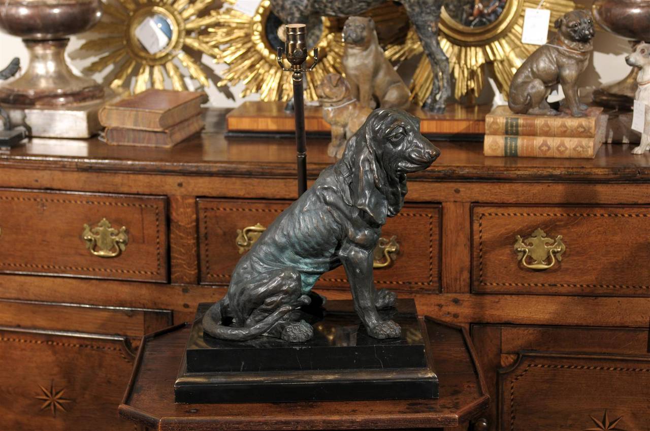 This bronze table lamp from the mid-20th century features a hound dog, in a sitting position with his tail neatly tucked and his front paws spread out. The attention paid to the details and the liveliness of the flesh shows an amazing craftsmanship.
