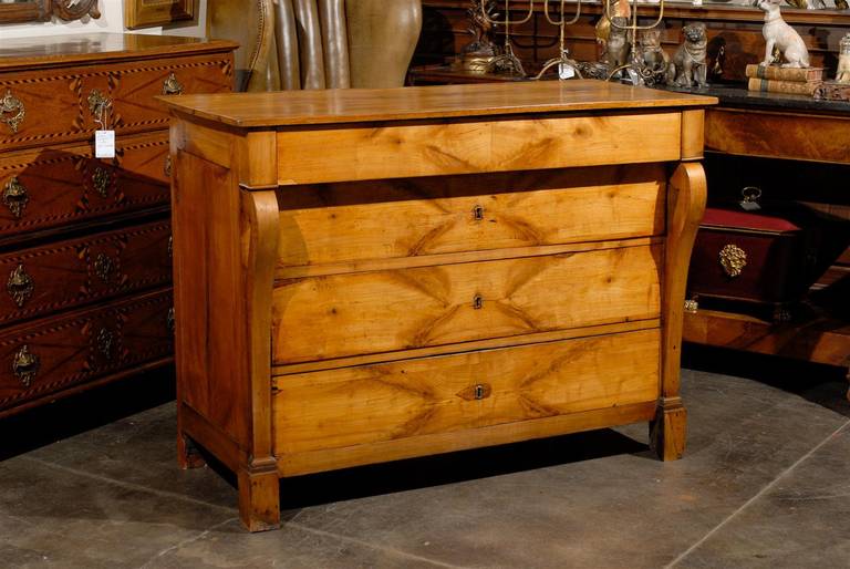 A French Empire period early 19th century, cherry four-drawer commode with volute legs. This early 19th French Empire cherrywood volute-shaped legs commode features a rectangular top over four drawers with a beautiful warm veneer. A pull-out drawer