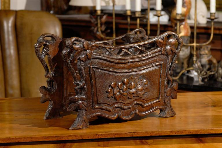 This Swiss (or German) black forest wooden planter or jardinière, circa 1880 is made of oak and features a petite nicely curved body decorated with wonderful carving made of foliage and branches. The planter is raised on four short feet shaped like