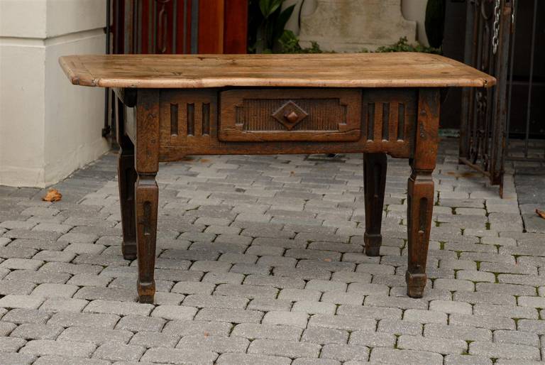 This exquisite Italian country table from the early part of the 19th century features a rectangular top with canted rounded corners over a simply carved apron with single drawer. This dovetailed drawer is decorated with geometrical motifs on a