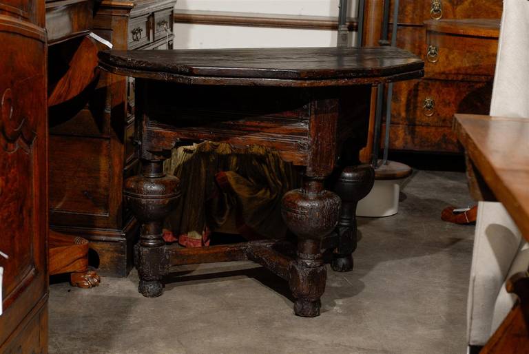 An Italian carved wooden gateleg demi-lune table from the late 18th century. This Italian table features a polygonal demilune top that opens up to double its depth. The table is supported by beautifully carved legs, alternating block joints with a