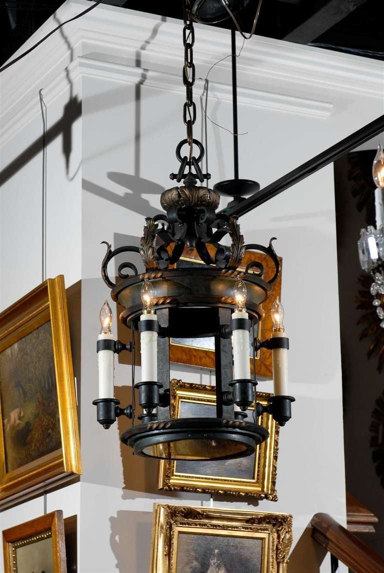 This French circular lantern consists of six new authentic wax candle sleeves attached by the cups and holders to metal strips connecting the two-ring bronze frame. Both rings have received carved twisted details enhanced by each glowing bulb, and a