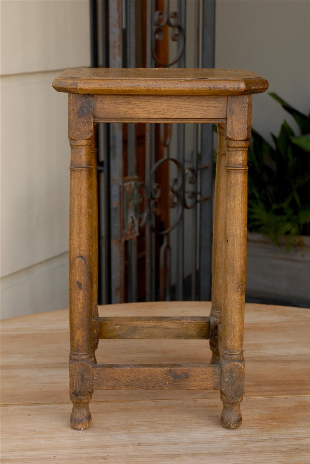 A four legged French stool from the late 19th century. This French stool or pedestal features a rectangular top with canted corners supported by four slightly slanted legs. The nicely shaped legs, with tops reminiscent of the simplicity of Doric