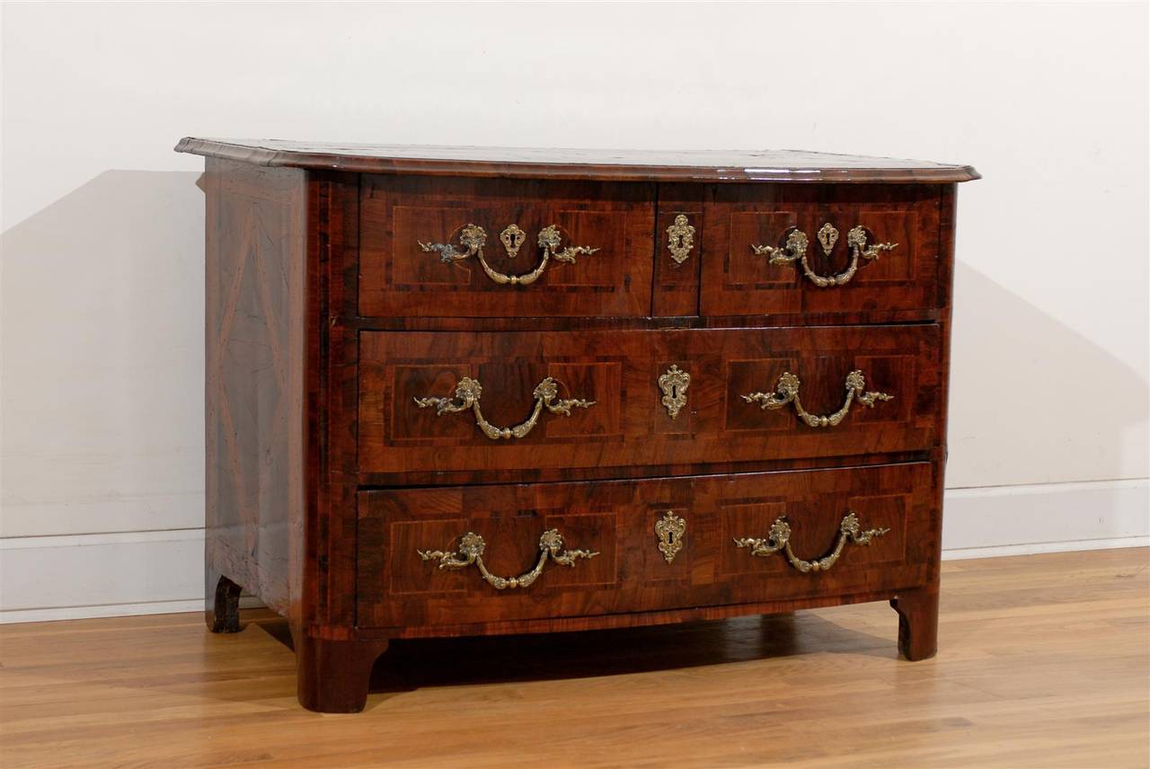 This French walnut five-drawer commode from the late 18th century features an exquisite top inlaid with geometrical motifs and a central star. Two smaller drawers sit atop two larger ones, all adorned with banding and beautiful hardware. The sides