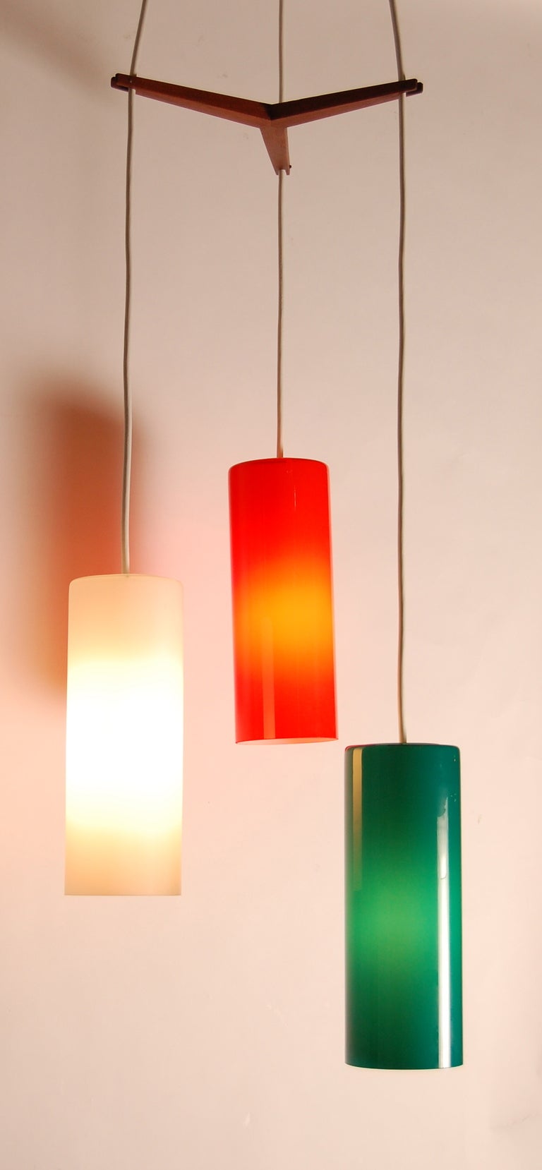 Three color pendant lamp from Denmark, the glass shades have a white translucent interior and there is inline wood spacer that separates the shades, the ceiling cap is also included. The pendant has a 17