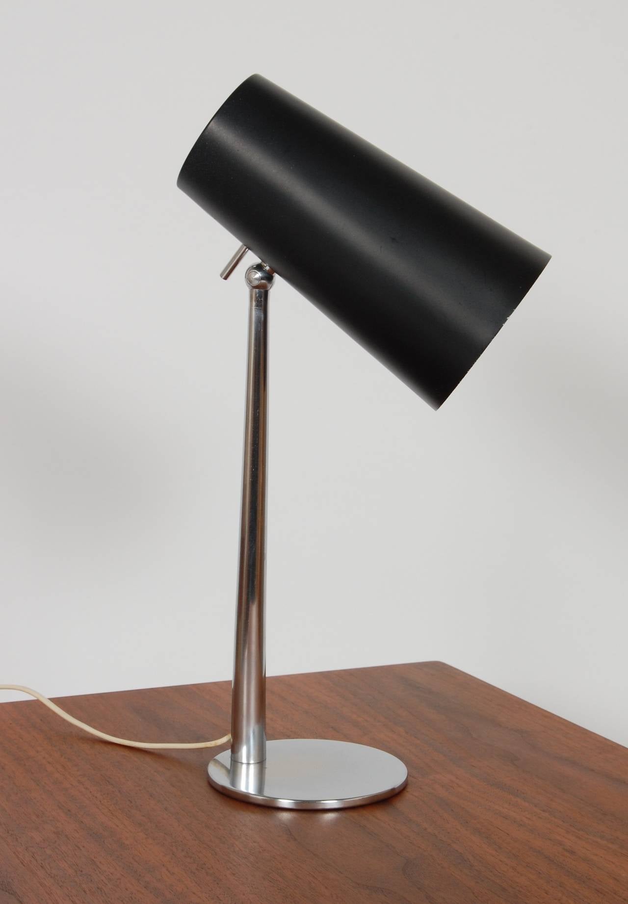 Brushed chrome base and stem with a black lacquer tapered cylinder adjustable shade. A wonderful compact design in lighting.