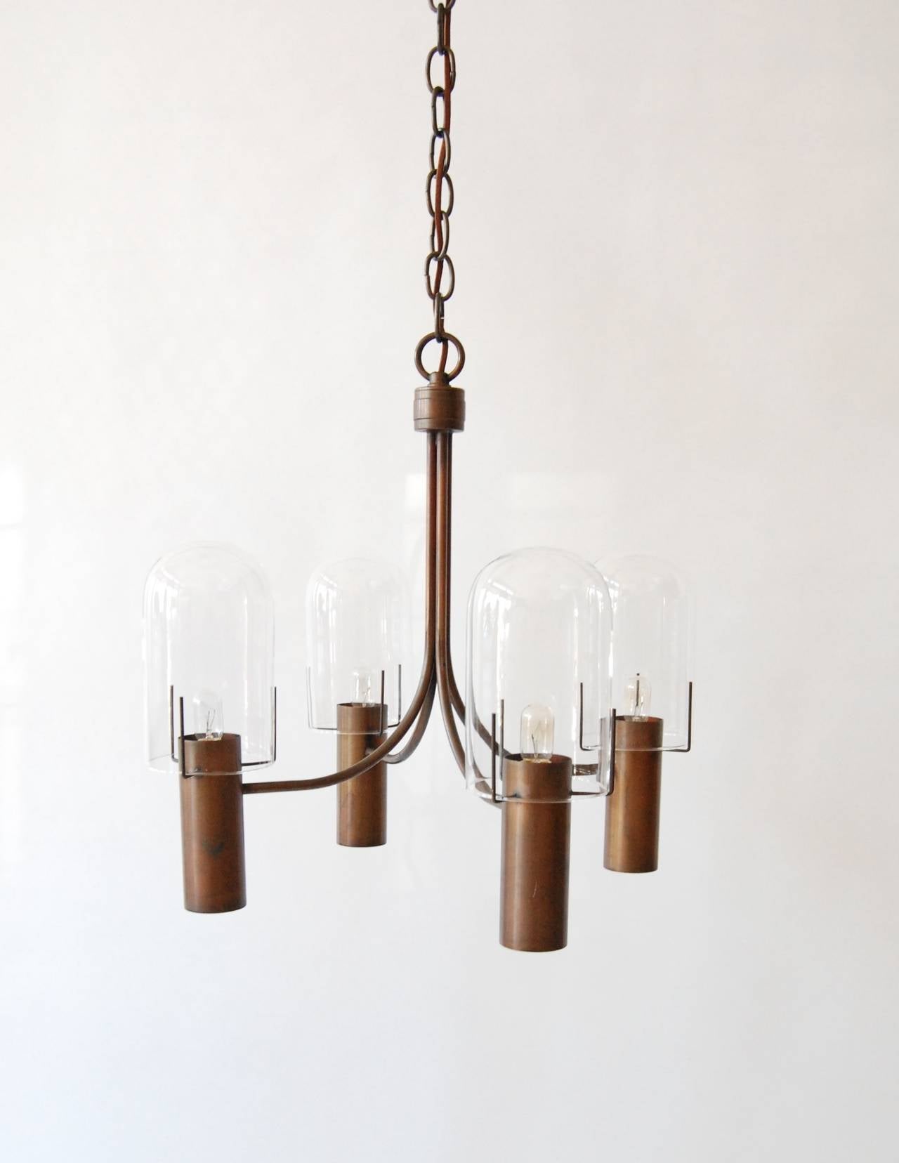 Four-arm canister lamp designed by Stuart Barnes for the Robert Long lamp company. Each canister has a top and bottom light, the top bulbs are covered with glass domes, the bottom ones are recessed inside the canisters. The lamp has a patinated