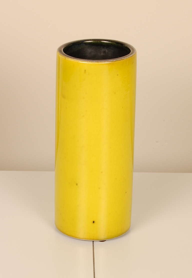 Ceramic cylinder vase by renowned France artist Georges Jouve 1910-1964 having a yellow glaze with a very slight green tint and a black interior. Incised on the bottom with the artist's mark.
