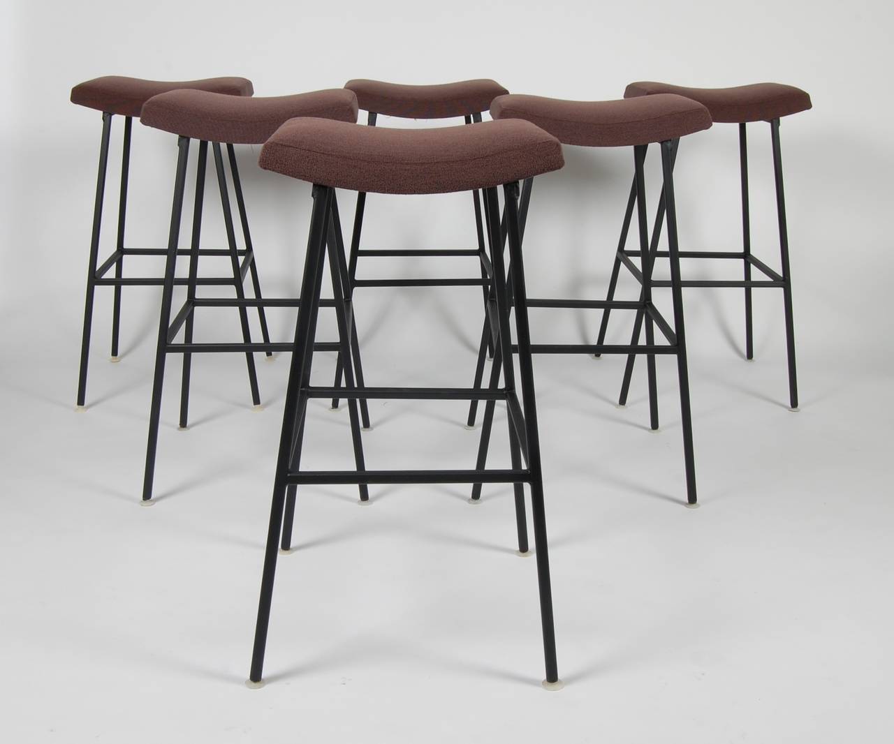 Six bar stools by Thinline of California, new upholstered curved seats, square tube iron frames with foot rests on all four side and newly enameled a flat black. Each stool has self adjusting glides.