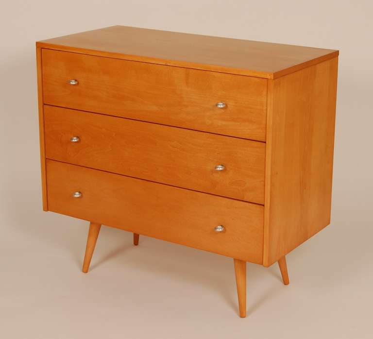 Compact dresser by Paul McCobb for his Planner Group line. Three drawers with aluminum ring pulls and splayed conical legs, the inside top drawer has the McCobb brand mark. Tastefully restored, fresh with a vintage hue.