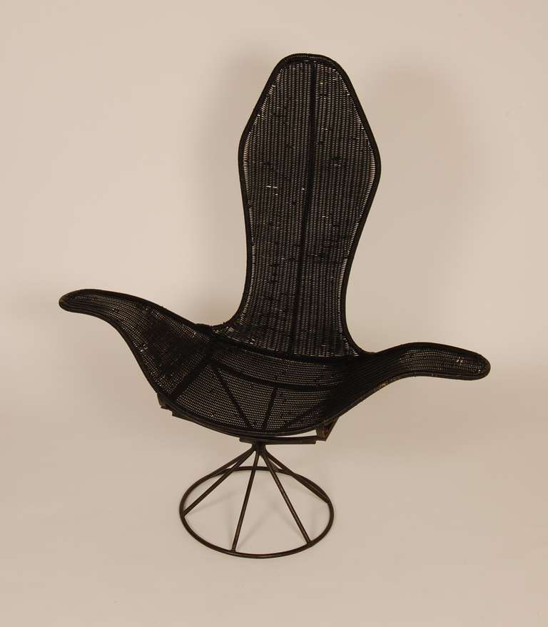 Modeled after the Laverne Petal Lounge is this wicker example with an iron base. This graceful form has a black metal frame with black wicker for the seat.