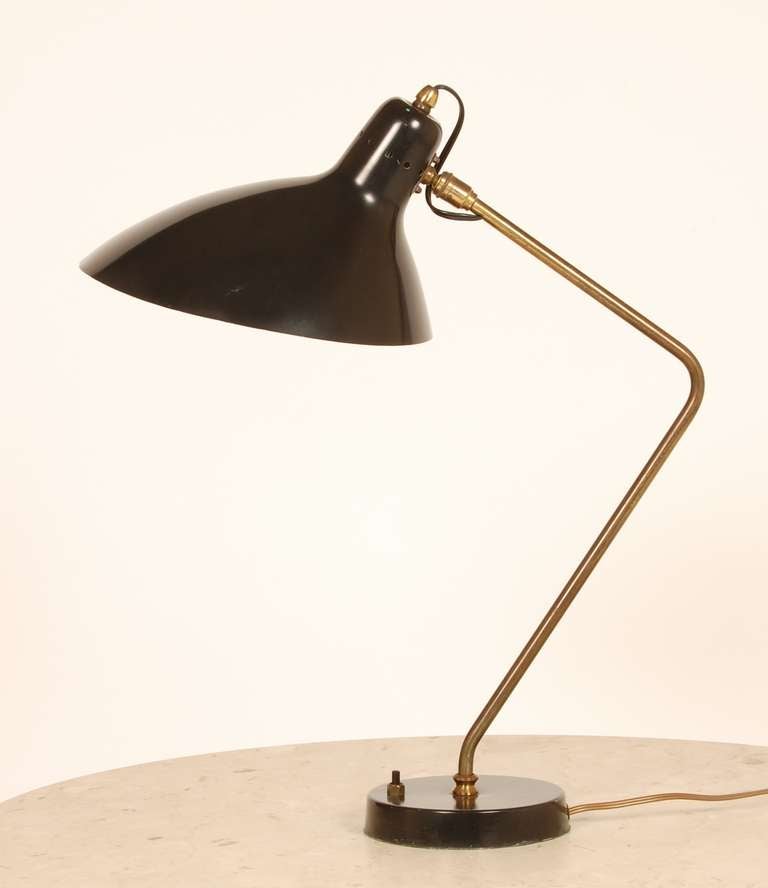 Table lamp by French born designer Jean-Boris Lacroix (1877-1984). Created in the 1950's, this brass and lacquered aluminum table lamp has a sculptural shade and a rakish angled stem. The base is circular with the push switch in front. Nice